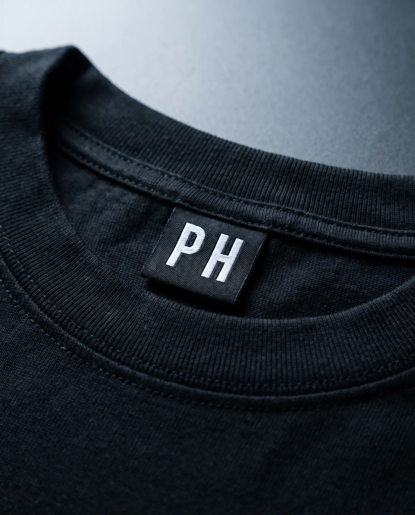 A close photograph of the woven neck label inside the collar.